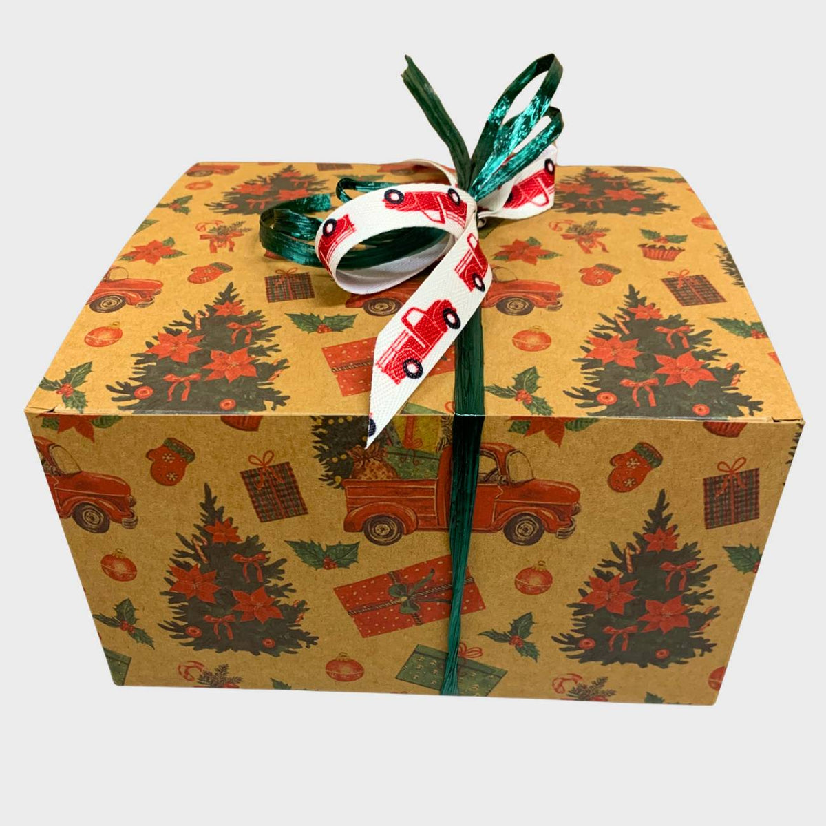 Gift box with Christmas-themed print featuring red trucks, and ribbon on a white background