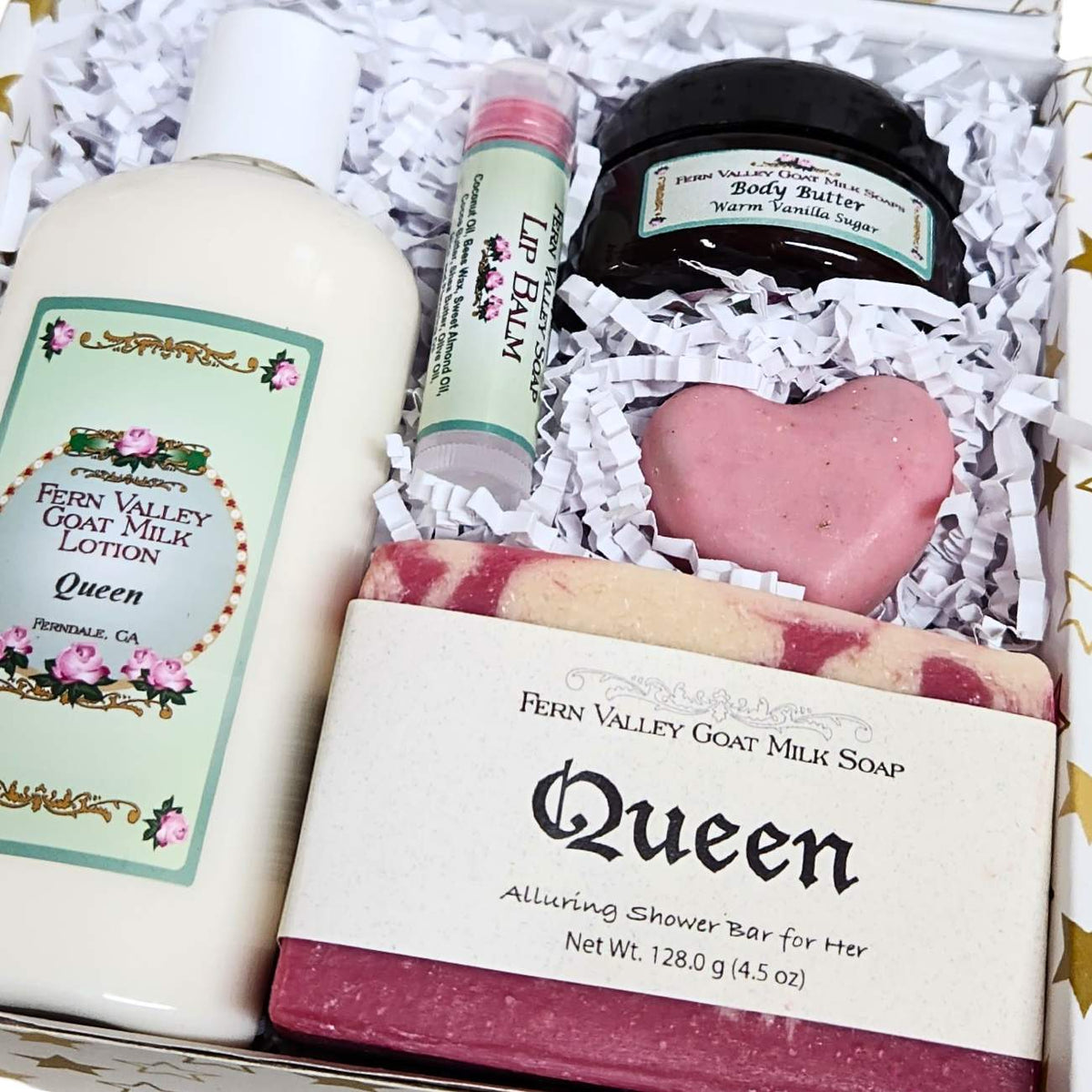 Hello Beautiful goat milk soap, Crisp Apple Rose lotion, a heart novelty soap, vanilla body butter, and a lip balm on white crinkle paper.