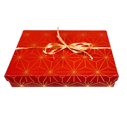  A closed luxury rectangular holiday gift box elegantly tied with a matching satin bow and holiday ribbon overlay, presented on a clean background.