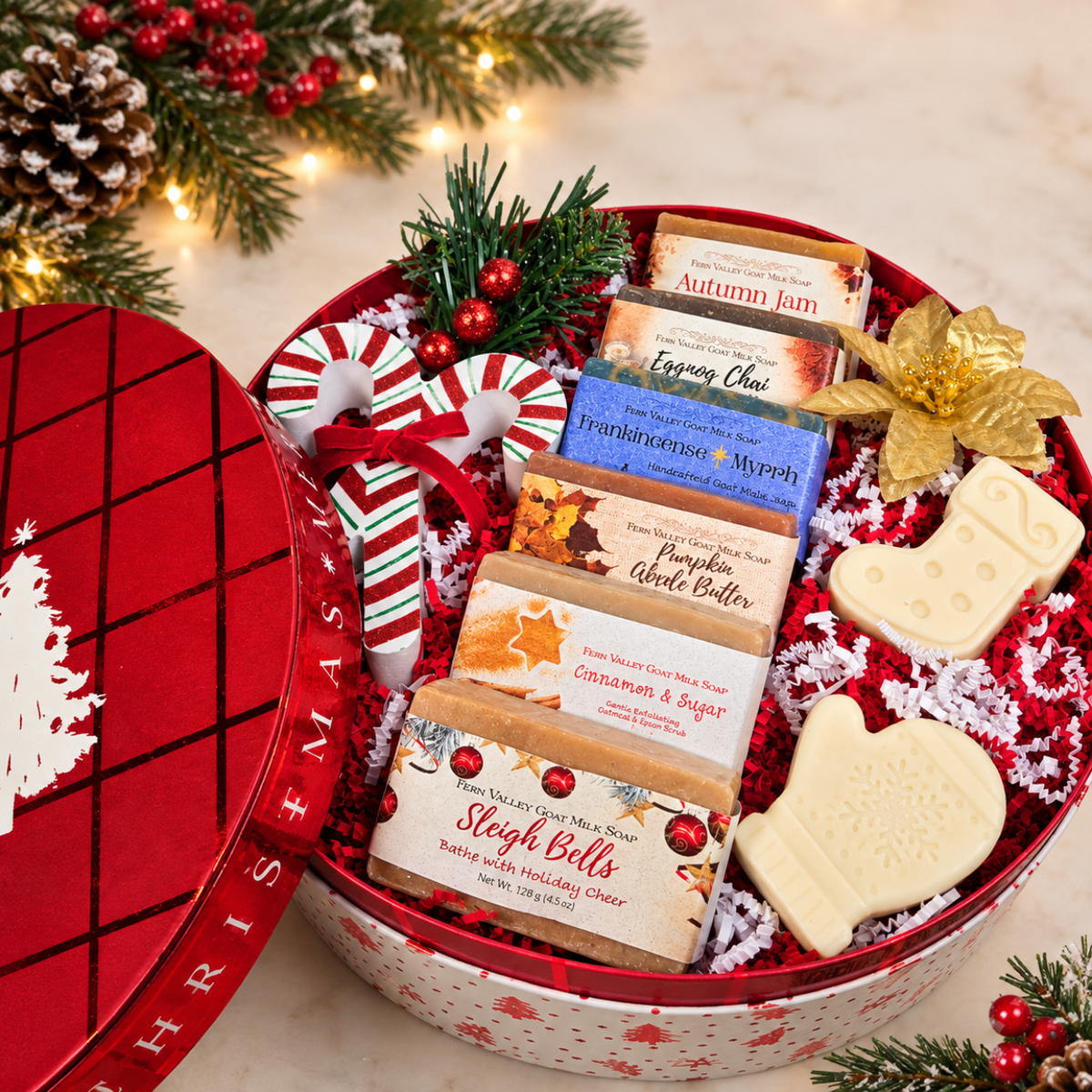 Premium round Christmas gift box filled with 6 bars of artisan goat milk soap, decorative candy canes, a mitten-shaped soap, and a stocking-shaped soap