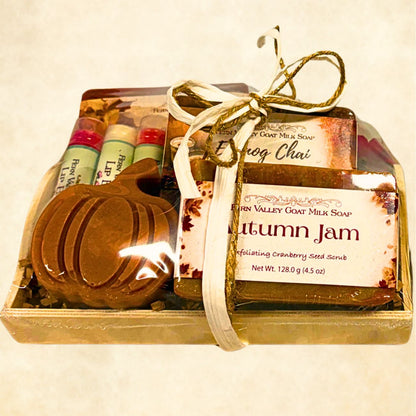 Shrink-wrapped wooden gift tray filled with brown crinkle paper, displaying Fern Valley Autumn Jam and Eggnog Chai goat milk soaps, a pumpkin soap, and three lip balms.