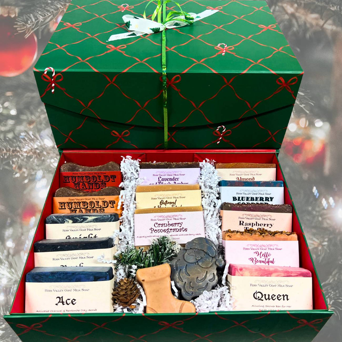 Open gift box with various soaps inside, featuring a green lid and red interior.
