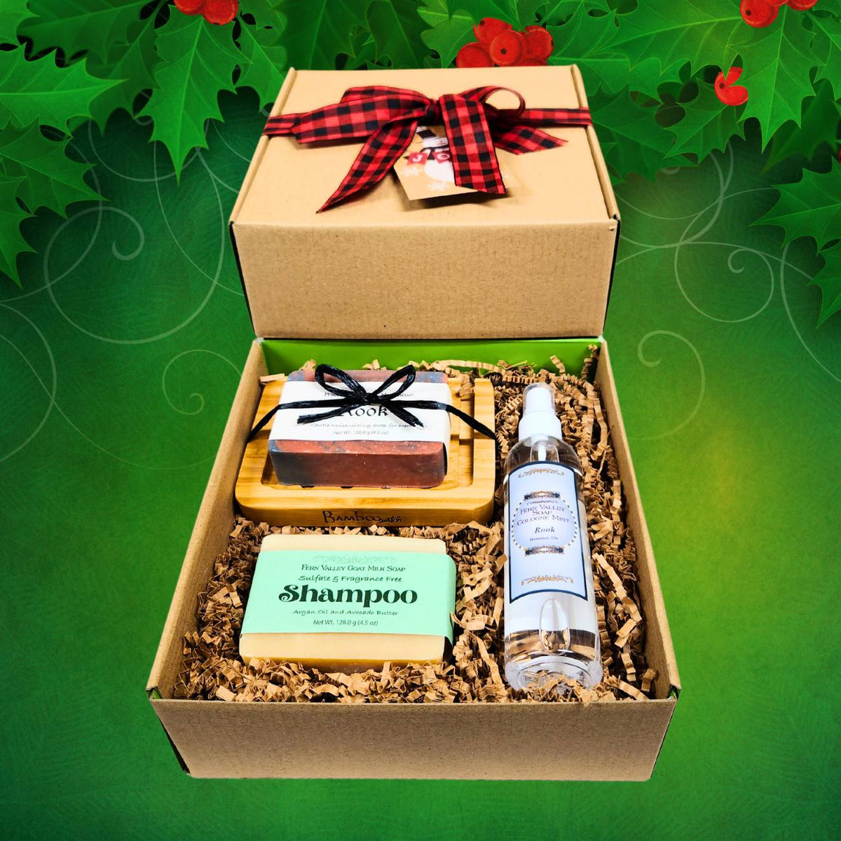 Handmade holiday grooming gift set for men in an open cardboard box decorated with a red buffalo plaid bow on a green holly with red berries background.