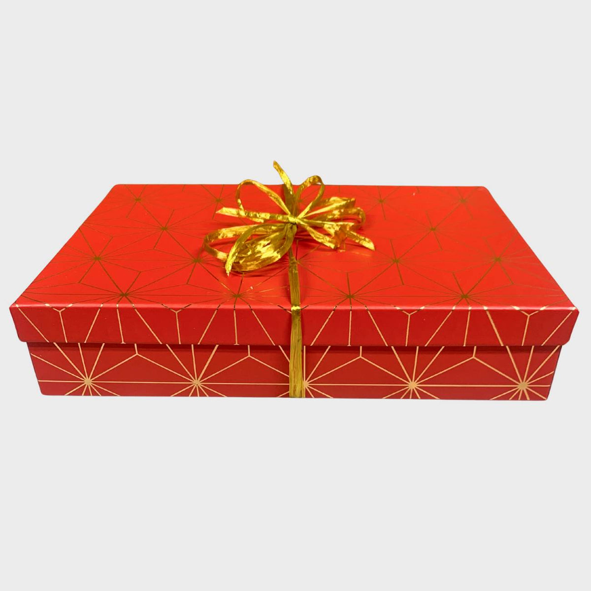 Red gift box with gold geometric pattern and gold ribbon on a white background