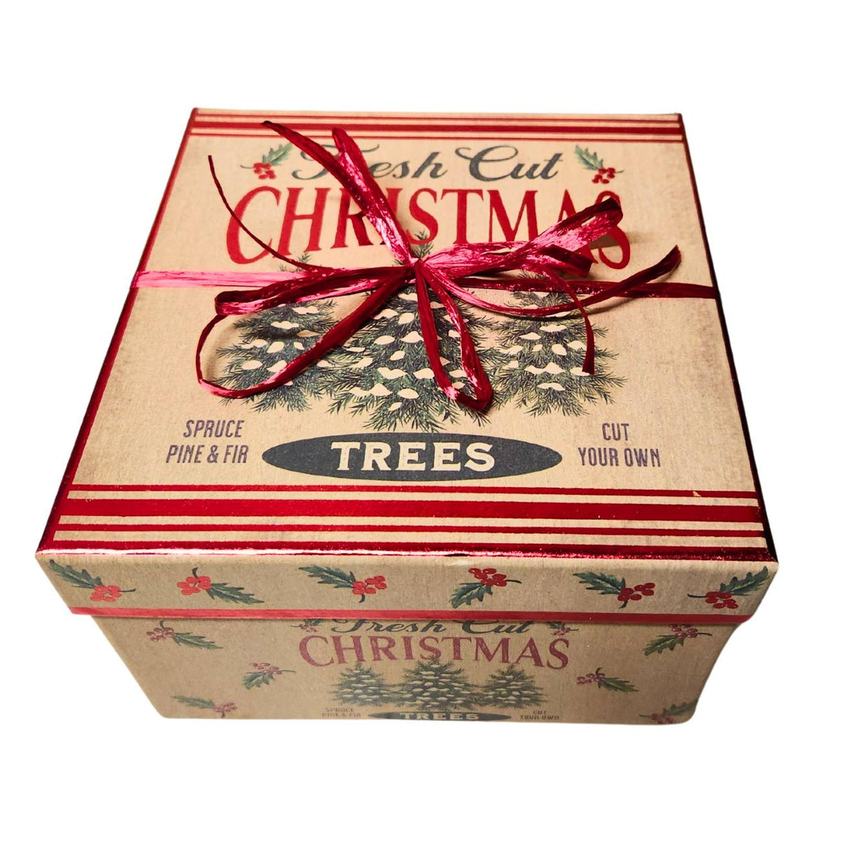 Kraft box with holly and ed berry trim. The box says Freshscut Christmas trees, it has a red bow tied around it. The image is on a white ground. 