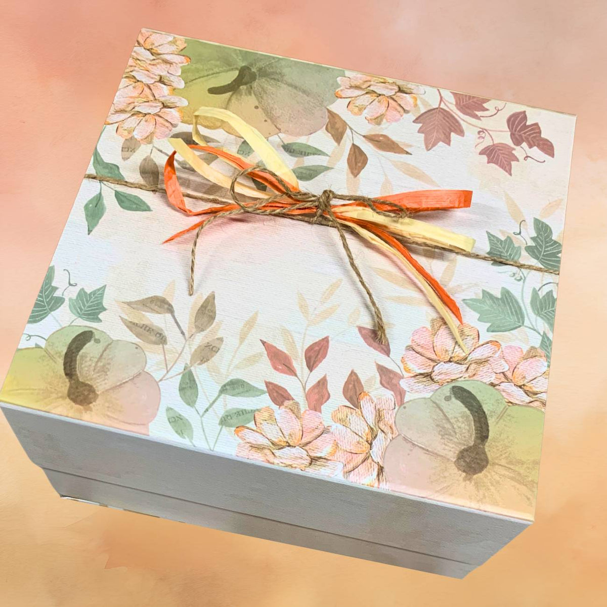 Decorative box with floral pattern and ribbon on a gradient background