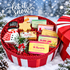 Round red-and-white striped Christmas gift box filled with handcrafted goat-milk soaps, a snowflake soap, and a snowman soap.